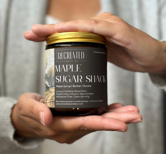 Person holding a jar of 'Maple Sugar Shack' by Recreated Maple Syrup